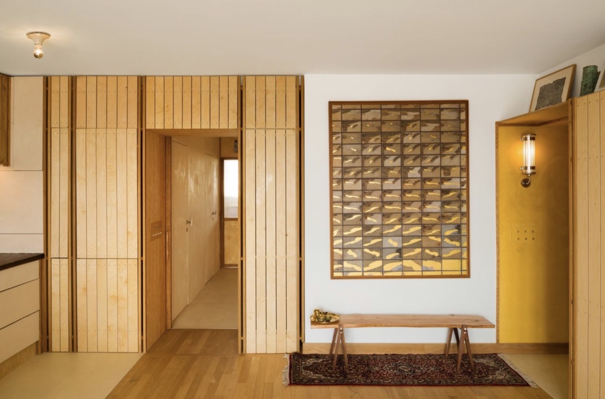 Plywood entryway with brass sconce
