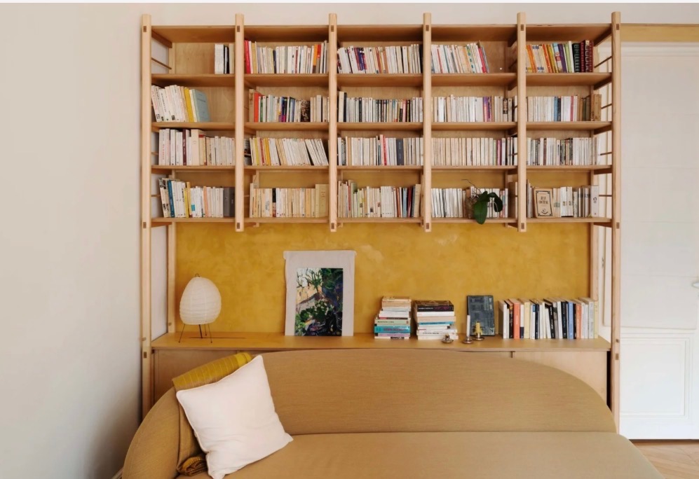 Bespoke plywood library with ochre backdrop